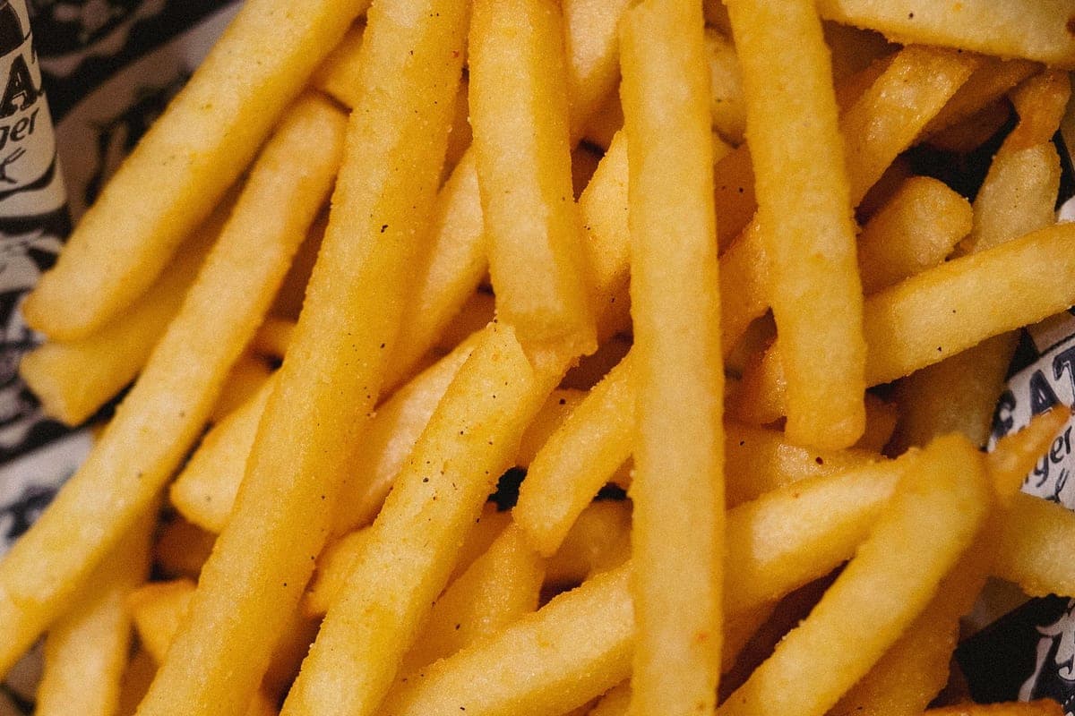 A pile of golden, crispy homemade French fries sprinkled with salt