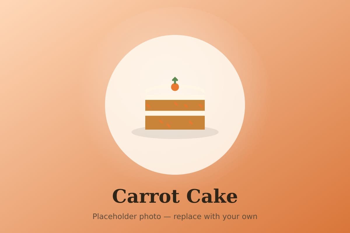 A two-layer carrot cake with swirled cream cheese frosting and chopped pecans, with one slice cut to show the moist, carrot-flecked crumb
